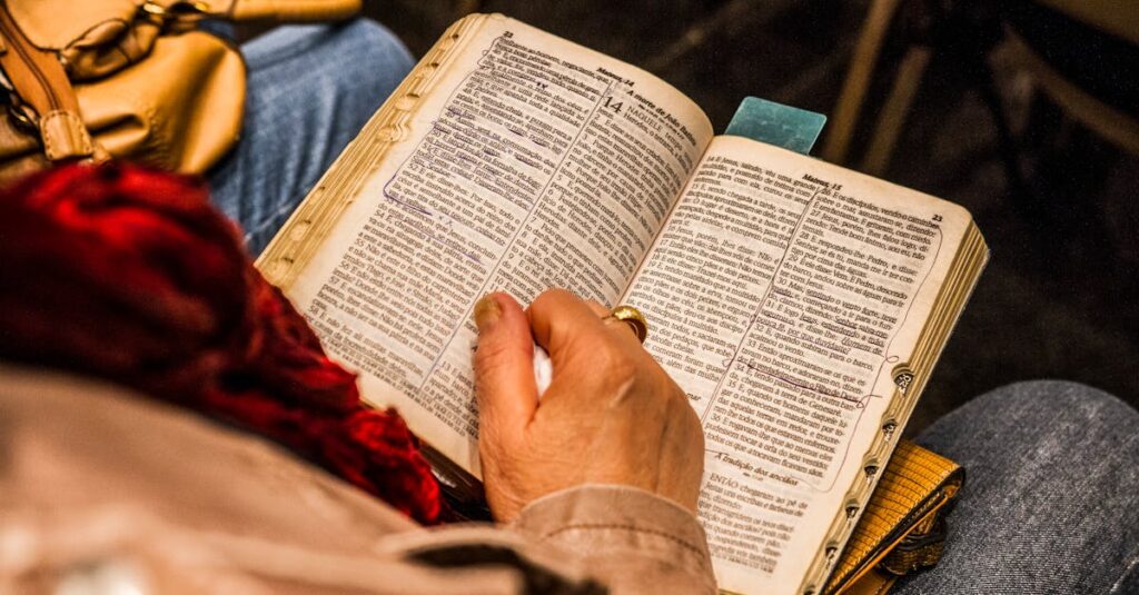 A person reading a Bible indoors, symbolizing spirituality and devotion.