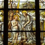 Detailed stained glass artwork illustrates biblical scenes in a church setting.