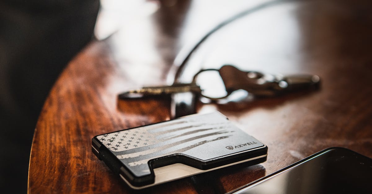 A wallet and keys placed on a wooden table with selective focus and warm tones.